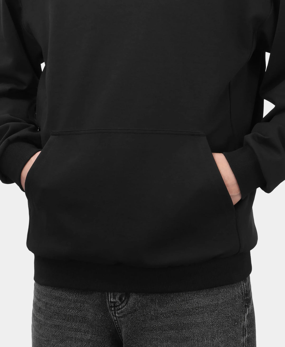 A black Toasty Unisex 5-Zone Heated Pullover Hoodie, shown in a close-up detail of the front kangaroo pocket with a model placing their hands inside.